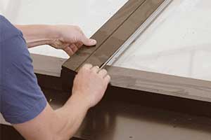 Installer clicking on cladding on a VELUX modular skylight